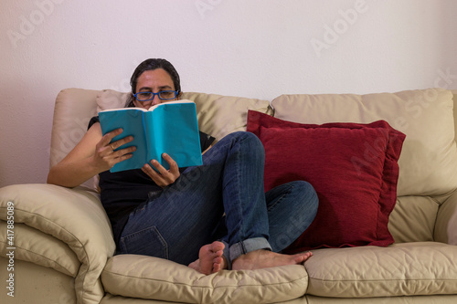 a girl enjoying a book on a sofa