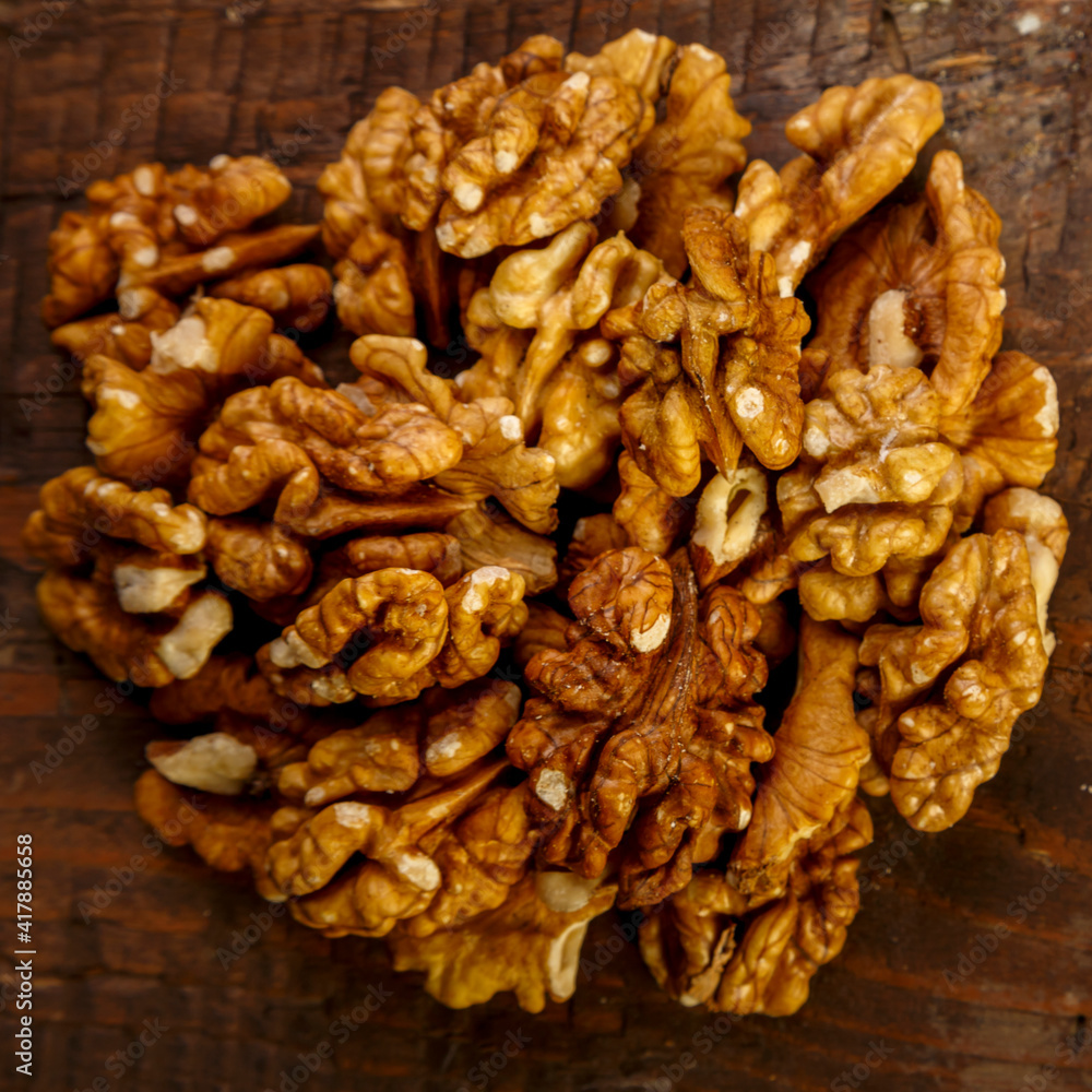 Walnuts scattering on a wooden table. Square
