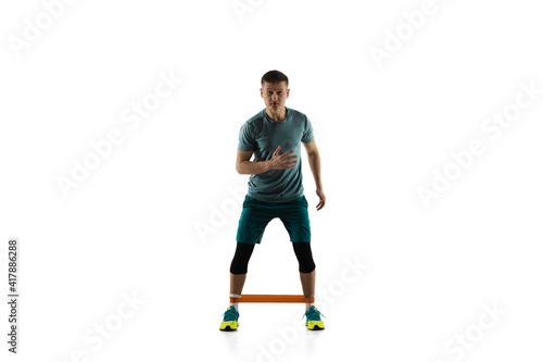 Work out. Young caucasian male model in action, motion isolated on white background with copyspace. Concept of sport, movement, energy and dynamic, healthy lifestyle. Training, practicing. Authentic.