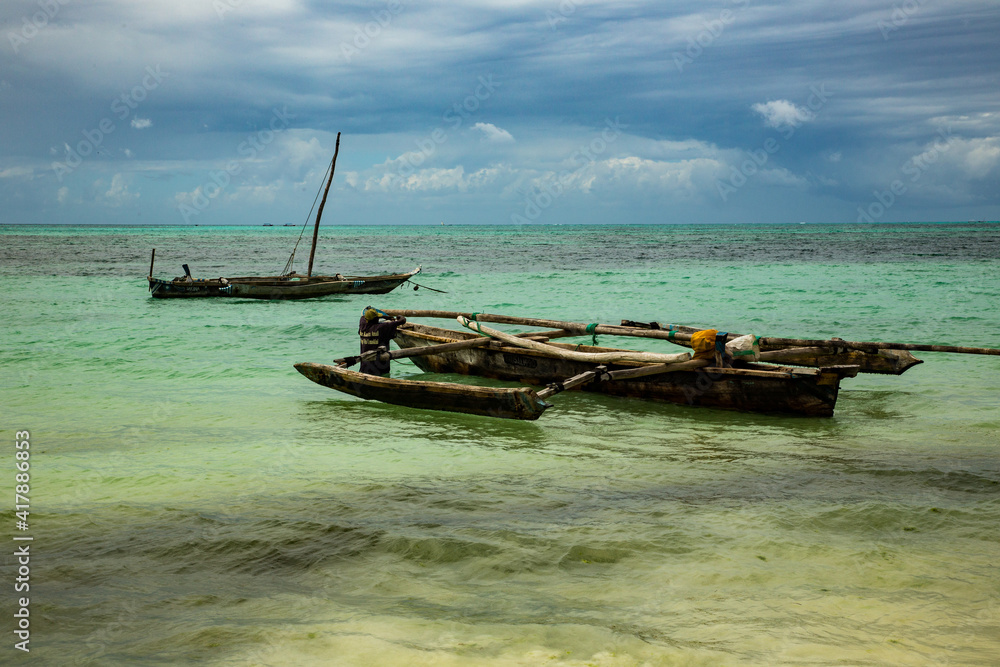 Jambiani, Tanzania, A local fisherman working on his traditional ngalawa sailing boat, Zanzibar. Jambiani, Tanzania, A local fisherman working on his traditional ngalawa sailing boat, Zanzibar.