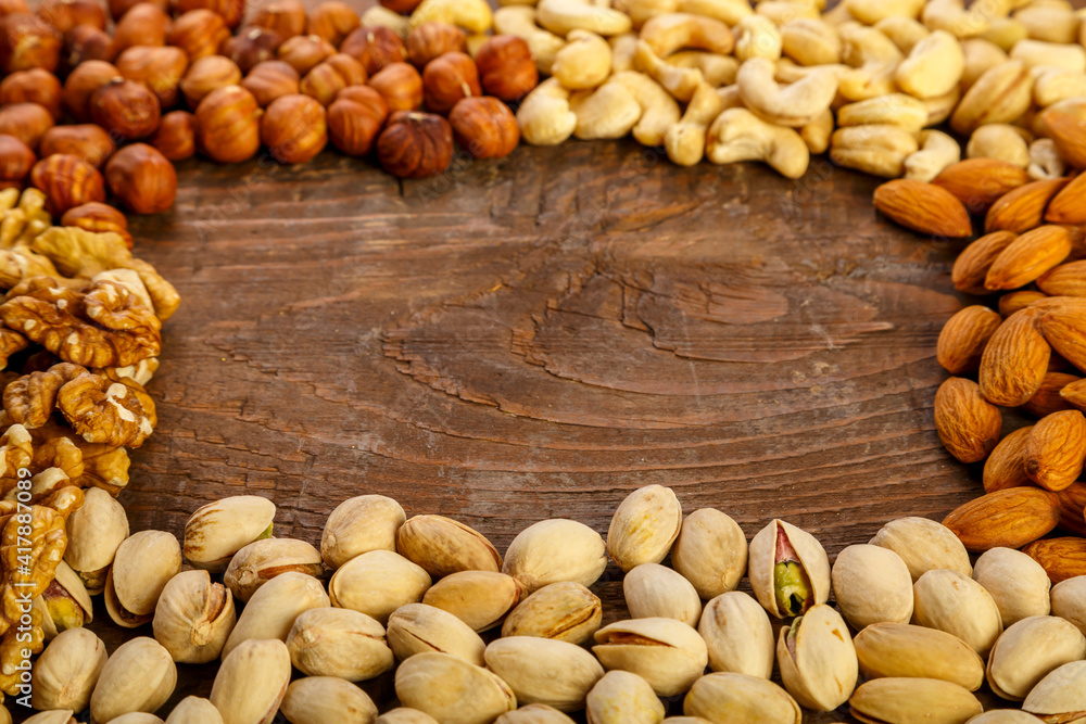Frame of assorted nuts on a wooden table. Copy space. Frame of assorted nuts on a wooden table. Copy space.