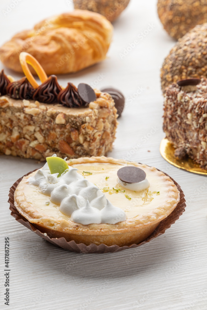 several desserts in study, there are pieces of cake and lemon pie with cream detail of the textures, pastry shop