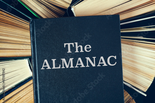 Old hardcover books with book The Almanac on top. photo