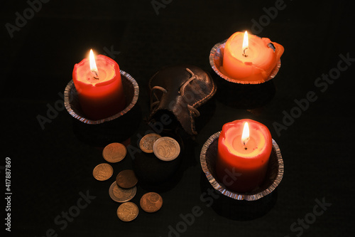 Euro coins dropped from the leather bag near the candles
