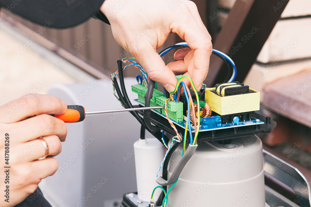 Technician man installing and checking the function of automatic gate Technician man installing and checking the function of automatic gate