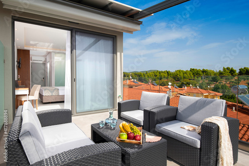 Summer panoramic view of roof top open terrace with wicker furniture in modern studio room apartment of European resort hotel