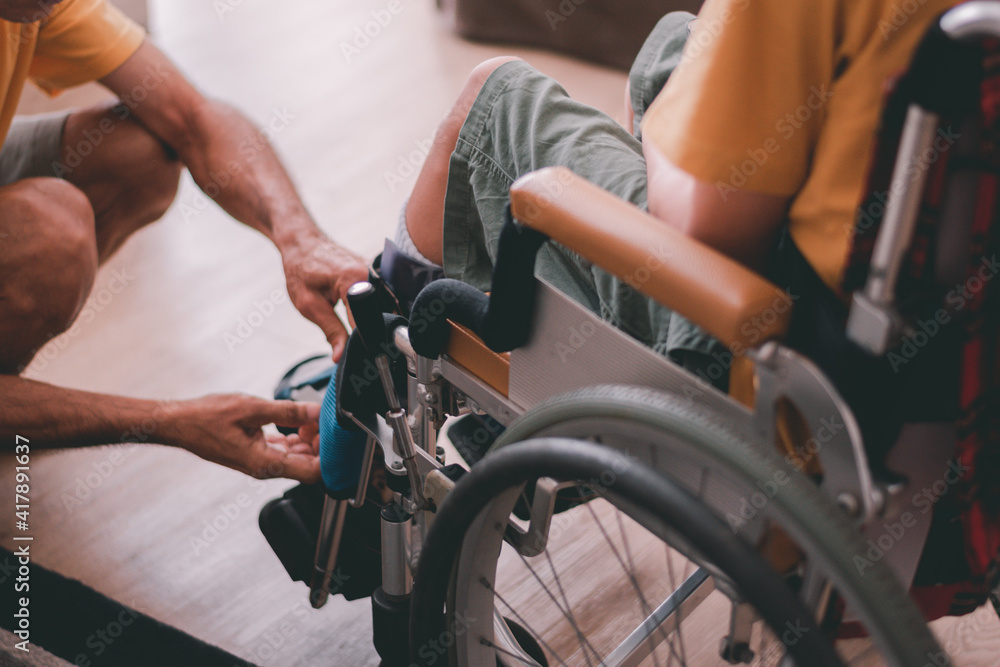 Fototapeta premium Asian special child on wheelchair and father activities in daily life in the home, Parents take care kid by love, Lifestyle in the education age of disabled children, Happy disabled kids concept.