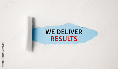 The text WE DELIVER RESULTS appearing behind torn white paper