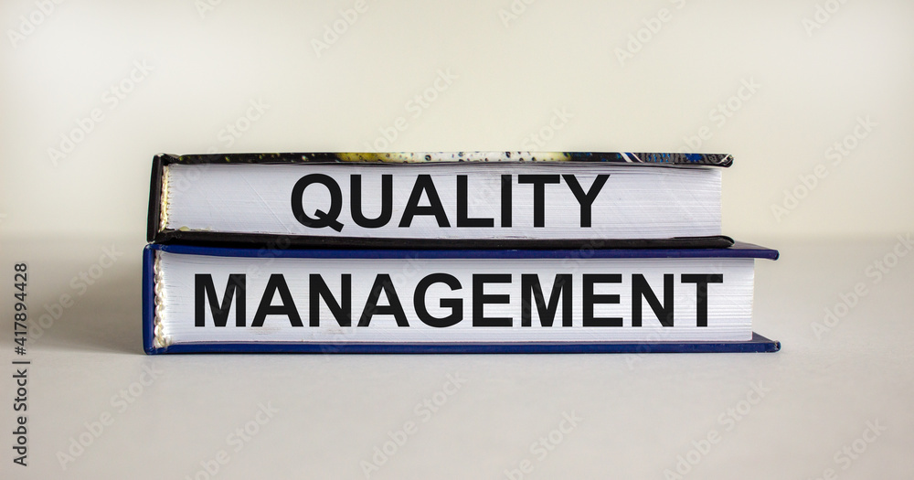 Quality management symbol. Concept words 'Quality management' on books on a beautiful white table, white background. Business and quality management concept.