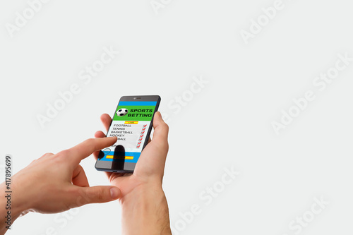 woman holding a mobile phone with sports betting website in the screen.