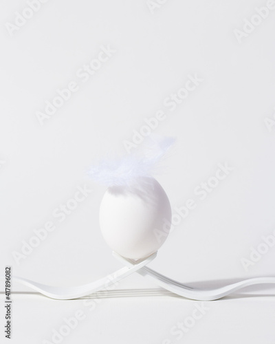 Minimal white Easter egg on bright background.