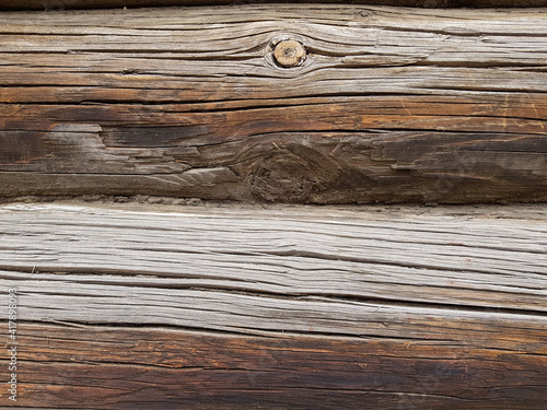 close-up as a background - the texture of an abandoned wooden house, a wall of old wooden blackened beams with slots, horizontally folded, connected by tow. In the countryside, outside the city. 