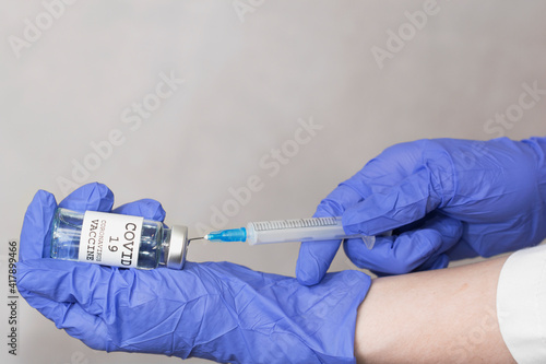 COVID-19 Coronavirus Vaccine. Doctor scientist with syringe analyzing virus Sars-CoV-2 in research for vaccine to be ready for clinical trial. Female researcher testing potential vaccine at the lab.