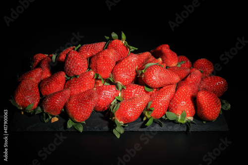 Sweet strawberries from Huelva on slate plate and with black background