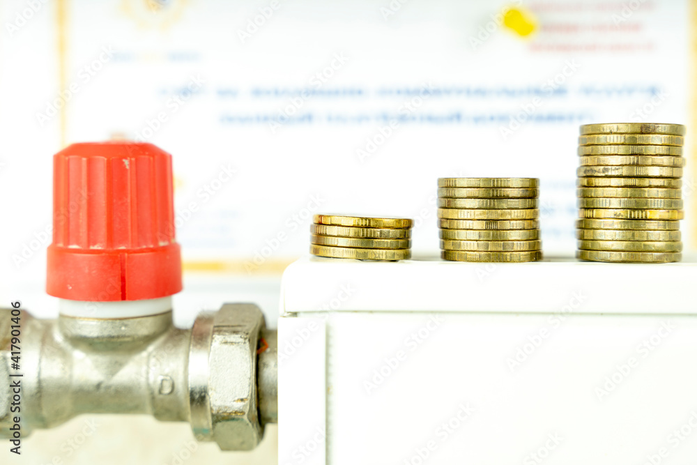 coins on the radiator, the concept of increasing utility bills coins on the radiator, the concept of increasing utility bills