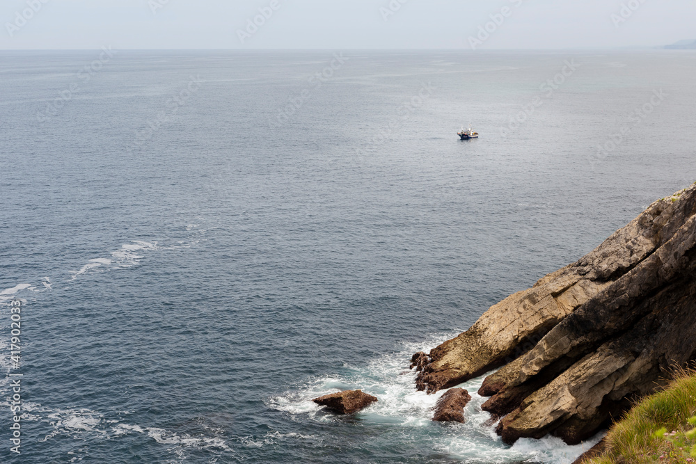 waves crashing on rocks and a boat waves crashing on rocks and a boat