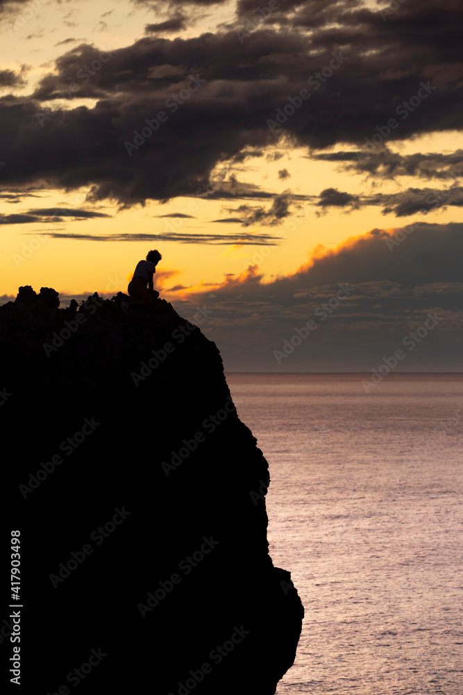 silhouette of people on the beach cliff at sunset silhouette of people on the beach cliff at sunset