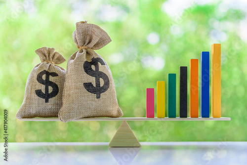 Fotografie Financial objectives for sustainable growth concept : US dollar bags, rising bar