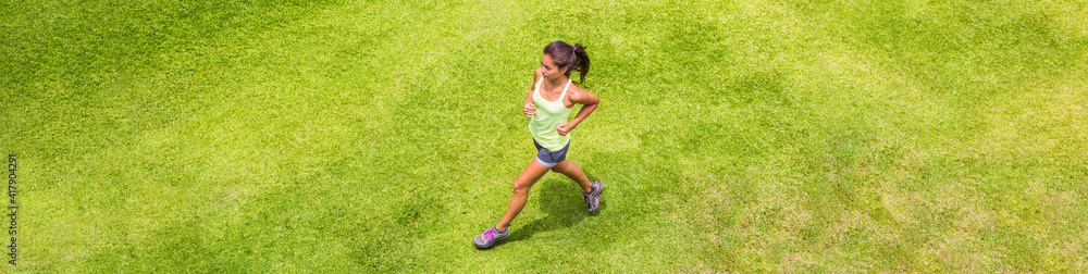 Runner woman running on grass background outdoor training for marathon. Top view of Asian sport athlete girl on hiit run. Banner. Runner woman running on grass background outdoor training for marathon. Top view of Asian sport athlete girl on hiit run. Banner.