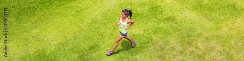 Runner woman running on grass background outdoor training for marathon. Top view of Asian sport athlete girl on hiit run. Banner.