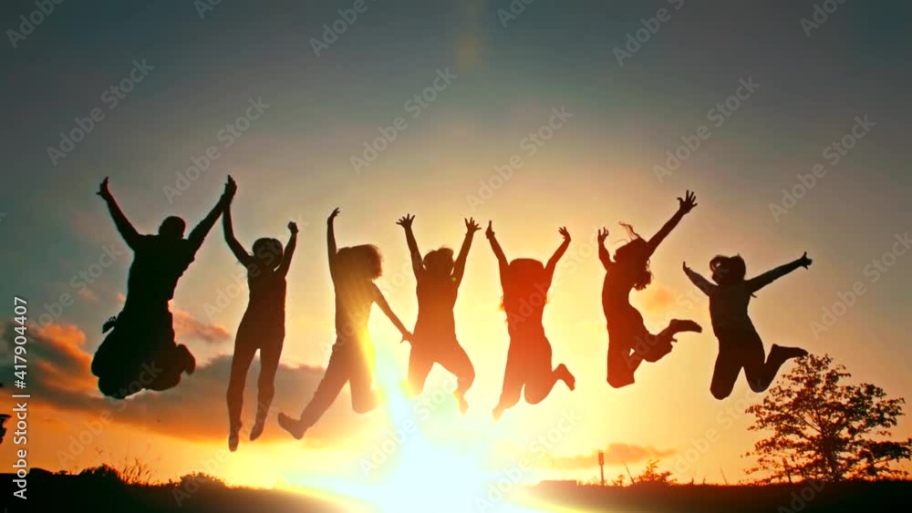 Silhouette of friends jumping in sunset Silhouette of friends jumping in sunset