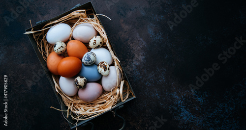 Vintage background with Easter eggs. Vintage kitchenware on dark background. Easter background with eggs and spring branches.Top view with copy space.