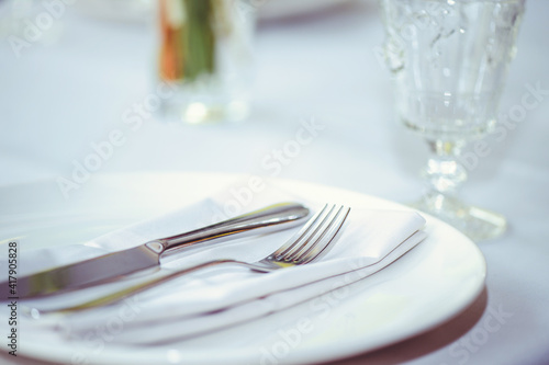 restaurant table setout with white plates and silverware