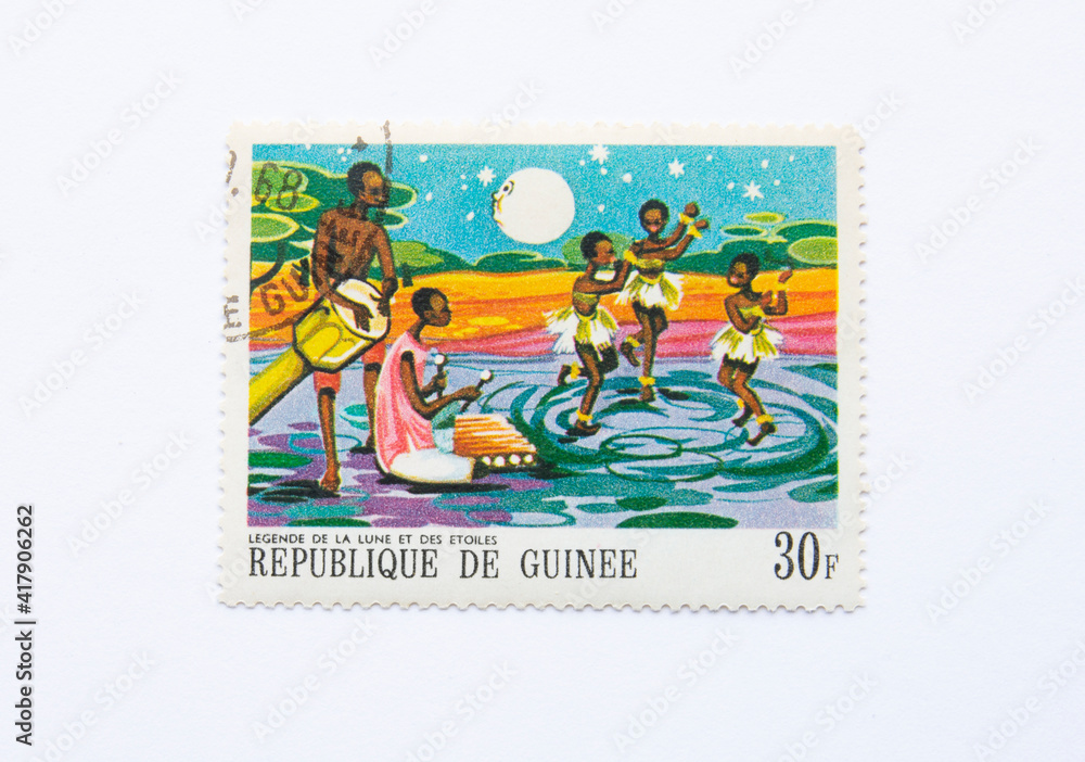 Guinea Republic Postage Stamp. circa 1968. 30 F. Legend of the moon and stars. African kids dancing at the night.