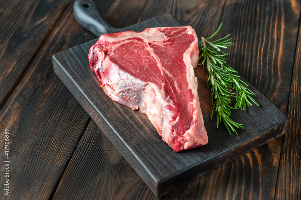 Raw T-bone steak with fresh rosemary