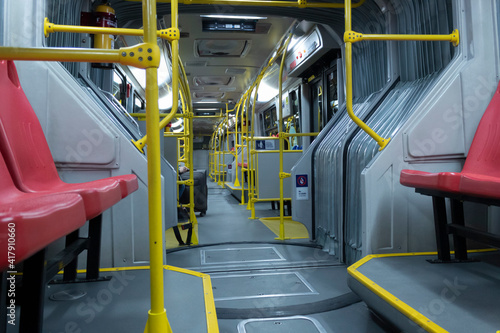 BOGOTA, COLOMBIA - A transmilenio bus inside at night with one person and travel bag.  photo