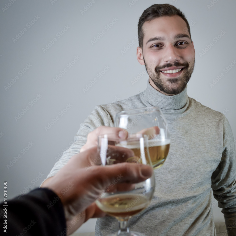 Portrait of a young man toasting with a glass of beer in his hand - personal point of view Portrait of a young man toasting with a glass of beer in his hand - personal point of view
