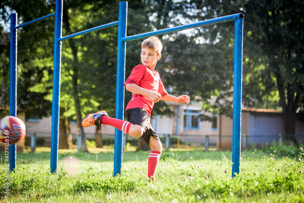 Emotional children play soccer in the summer in red uniforms. Emotional children play soccer in the summer in red uniforms.