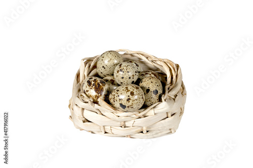 Boiled spotted quail eggs in a wicker basket, isolated on white background.  Healthy Food Products Concept.