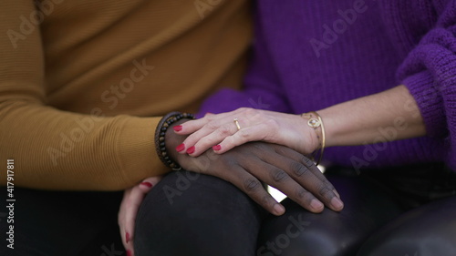 Girlfriend hand caressing boyfriend. Interracial diverse couple, close-up hands © Marco