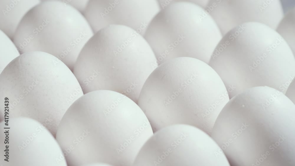 Lots of fresh raw chicken eggs in a cardboard box, rotation shot, Chicken white fresh raw eggs in an egg container Lots of fresh raw chicken eggs in a cardboard box, rotation shot, Chicken white fresh raw eggs in an egg container
