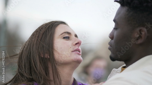 Interracial couple kissing, candid tender affection millennial couple