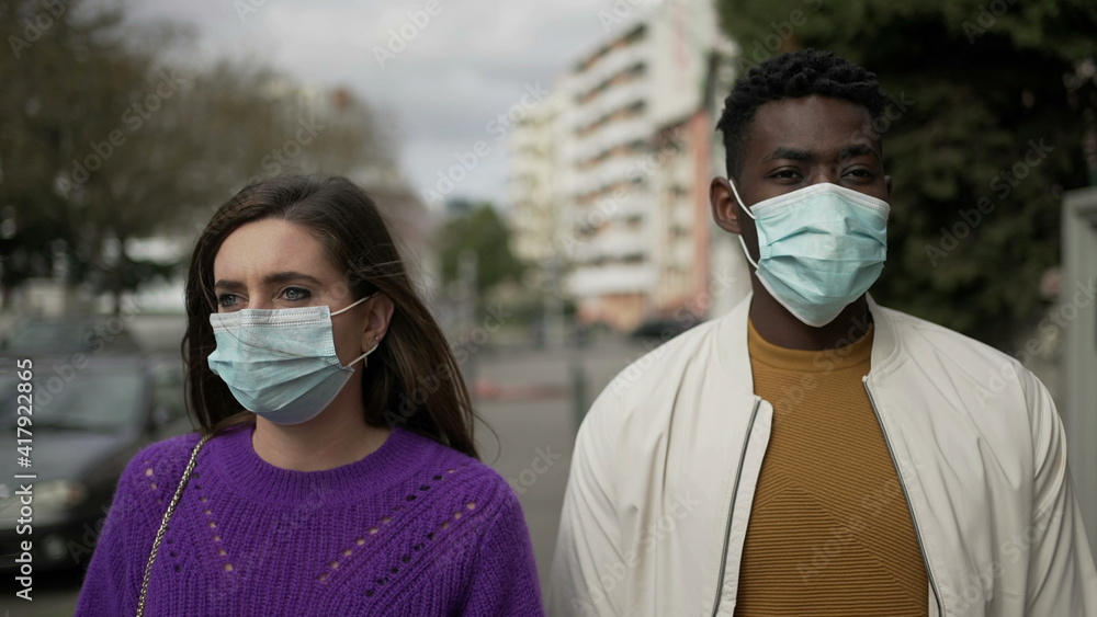 Interracial couple putting covid-19 face mask prevention. Diverse people put surgical mask