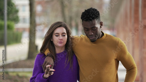 Interracial couple relationship. black man arms around girlfriends walking together outside