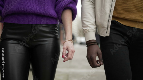 Interracial couple walking together in city sidewalk