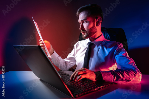A man works on a laptop. A ...