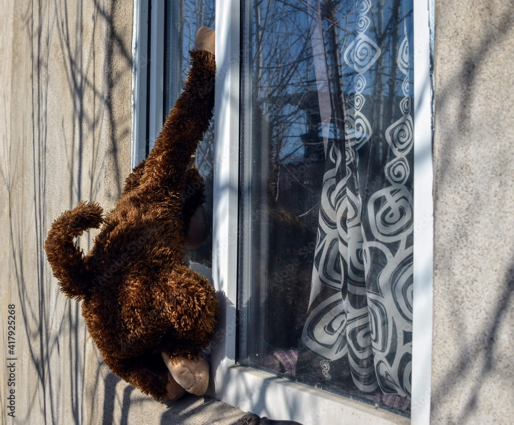 A toy monkey peeps through the window. The concept of voyeurism.
