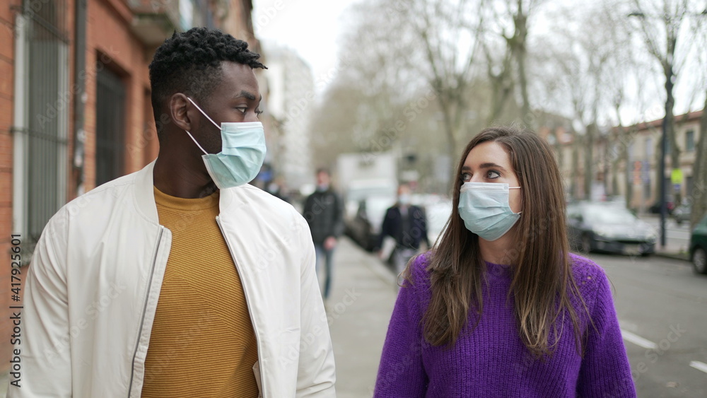 People wearing covid-19 face mask walking in street outside