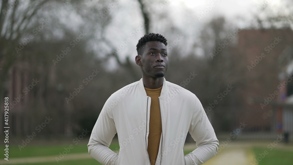Thoughtful African man walking outside. Pensive meditative person daydreaming Thoughtful African man walking outside. Pensive meditative person daydreaming