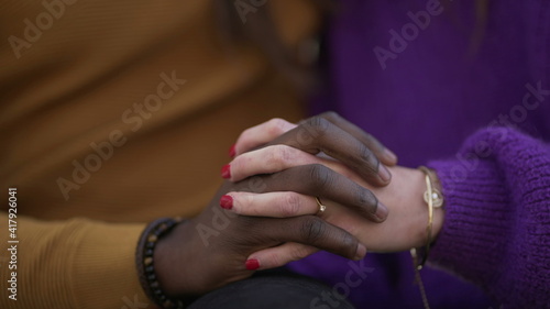 Two people joining hands together, diversity concept. interracial couple close-up hand © Marco