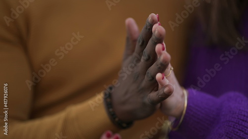 Two people joining hands together, diversity concept. interracial couple close-up hand