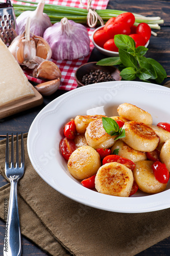 Artisan gnocchi stuffed with cheese, with cherry tomatoes, garlic, olive oil and basil