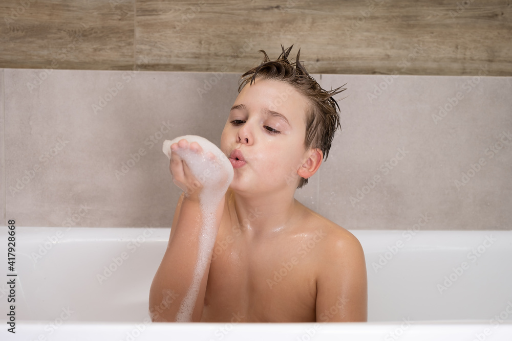 Funny boy playing with water and foam in a bathroom Cute happy child bathe at home healthy childhood Funny boy playing with water and foam in a bathroom Cute happy child bathe at home healthy childhood