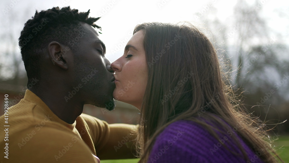 Young interracial couple kiss. Millennial lovers, African and white couple Young interracial couple kiss. Millennial lovers, African and white couple