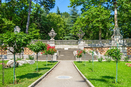 Old stone stairway with columns and bowls and ornaments among flowers and trees. It's part of Massandra park complex near Yalta, Crimea