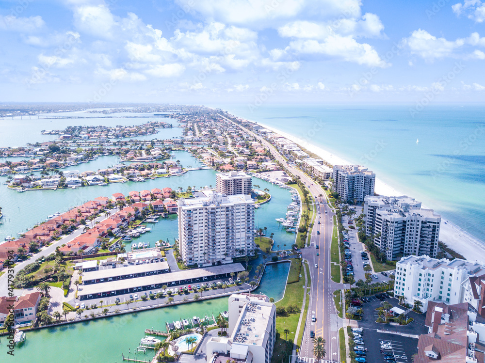Fototapeta premium Island in Gulf of Mexico. Ocean or shore. Spring break or Summer vacations in Florida. Hotels, restaurants and Resorts. Tropical Nature. Clearwater Beach FL. Aerial view.